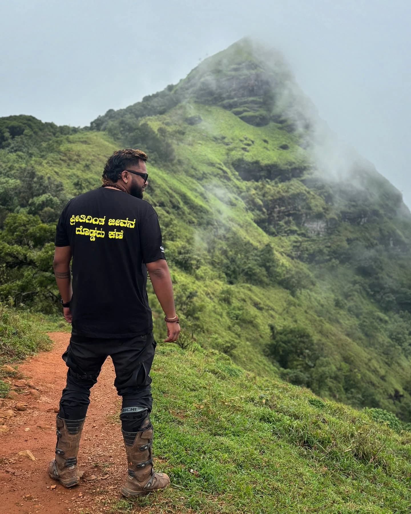Rider standing on a misty green mountain trail