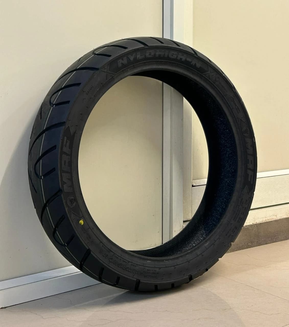MRF Nylohigh motorcycle tyre displayed upright showing sidewall and tread design