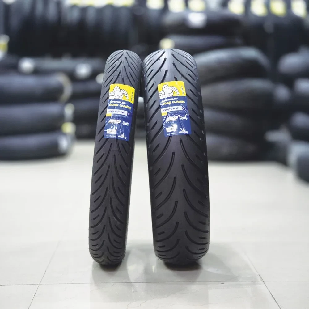 Pair of Michelin Road Classic motorcycle tyres displayed in a tyre showroom