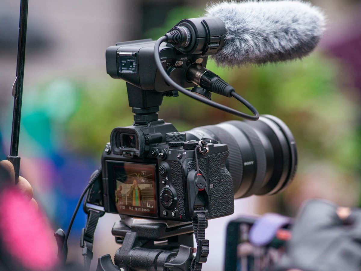 Video camera with a shotgun microphone recording on a tripod