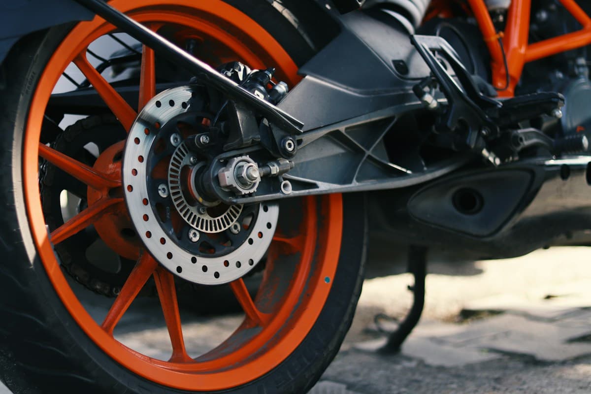 Close-up of a motorcycle tyre on an orange alloy wheel